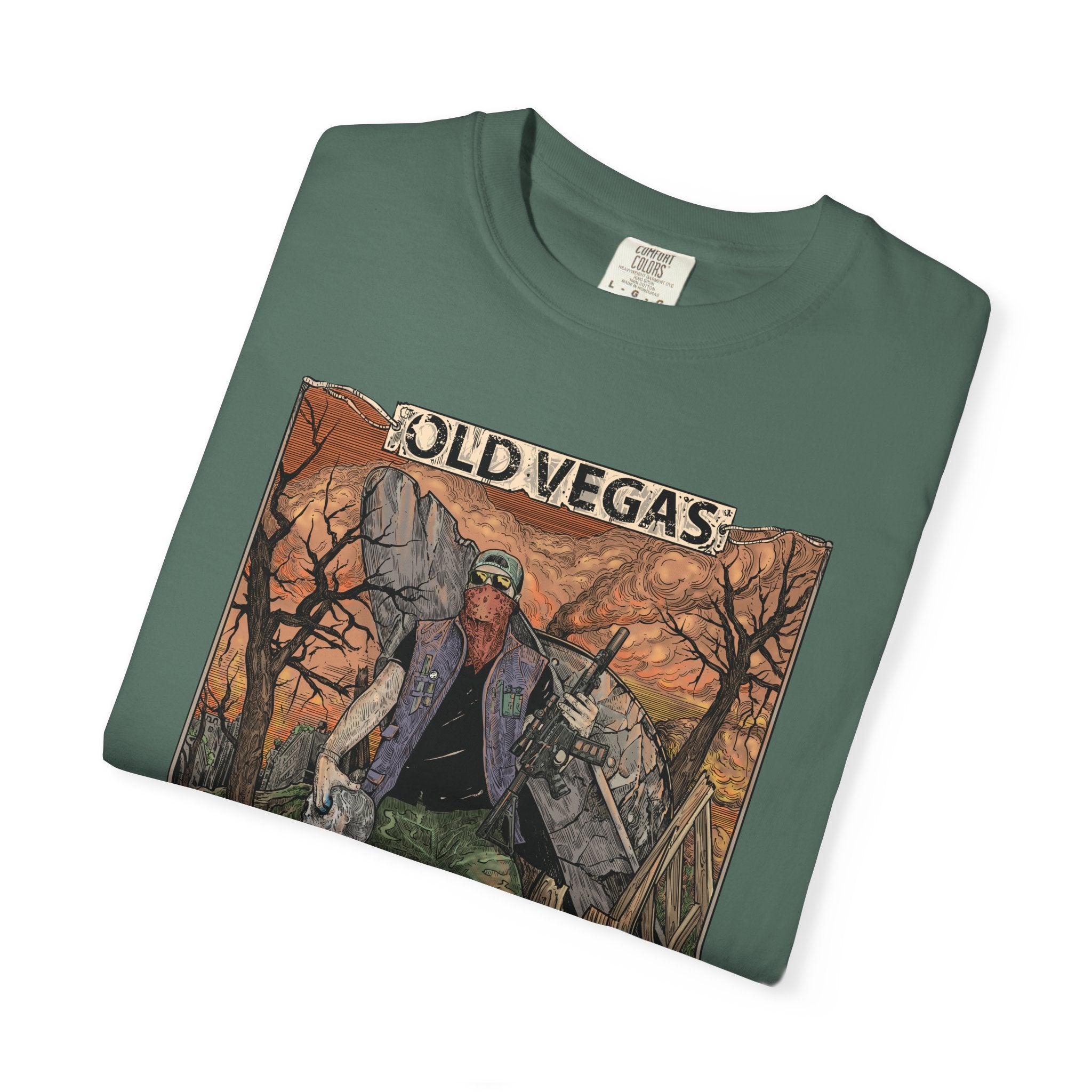 A folded dark green cotton graphic tee featuring a rugged figure in an old vegas desert scene with warm tones