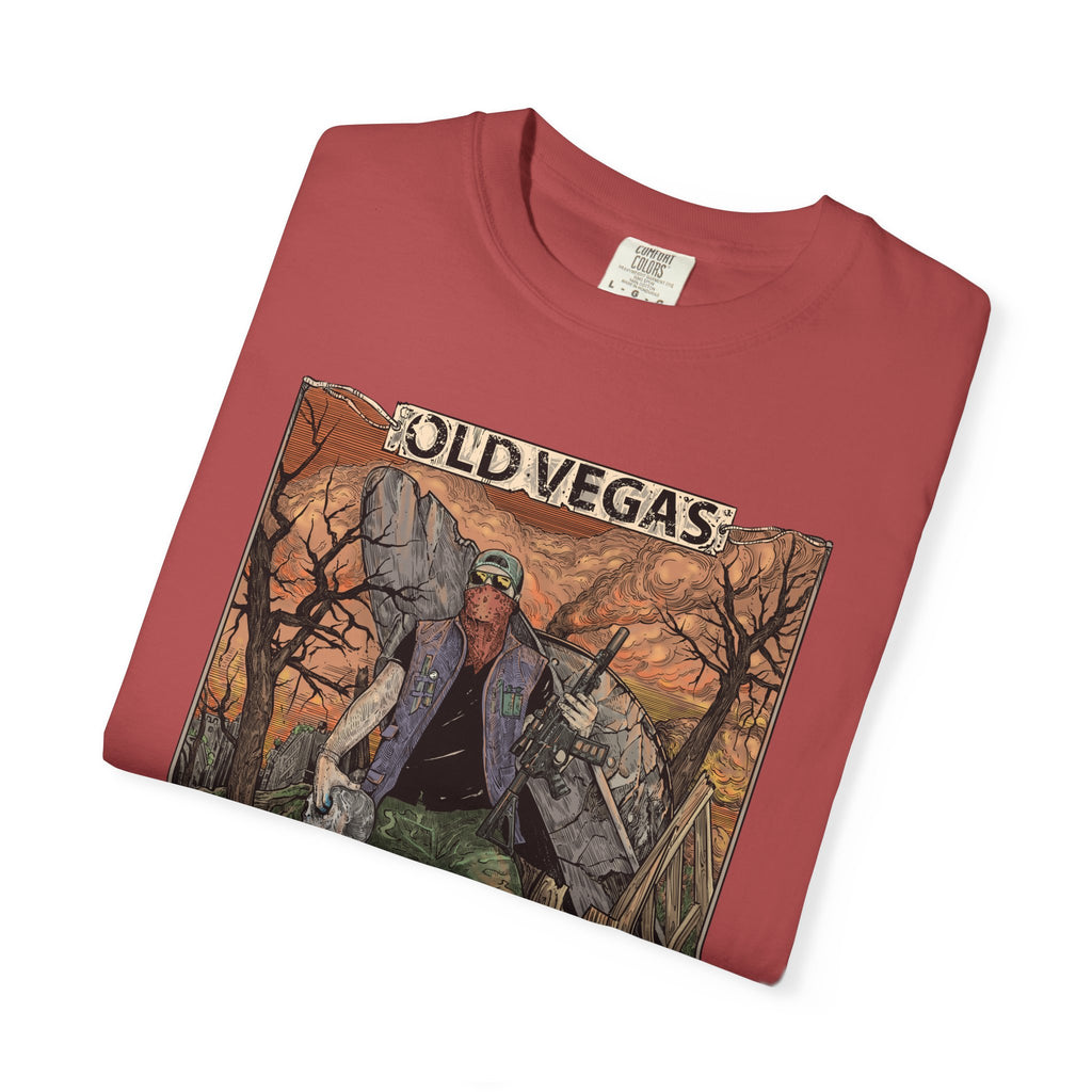 A folded red cotton graphic tee featuring an old vegas themed rugged figure in warm orange and brown tones