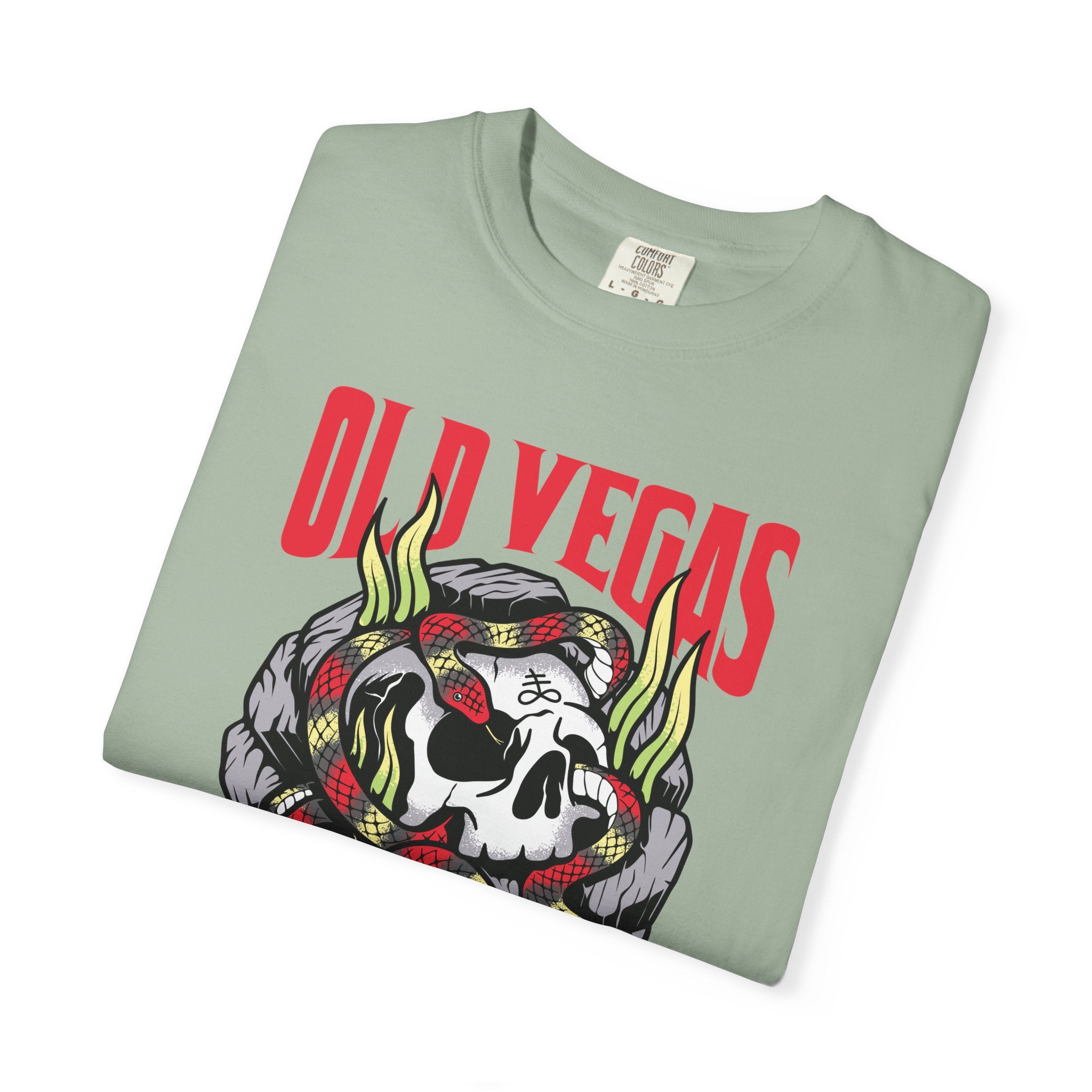 A folded light green cotton t-shirt with a bold red old vegas graphic and skull snake flames design