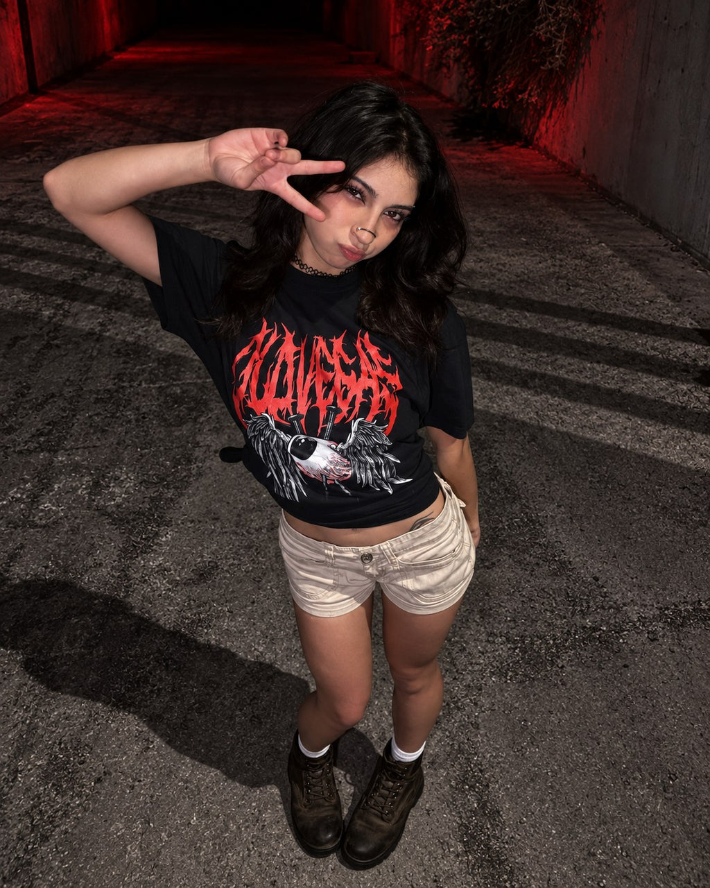 High-angle view of a model making a peace sign in the OLD VEGAS Dead Eyes black graphic tee.